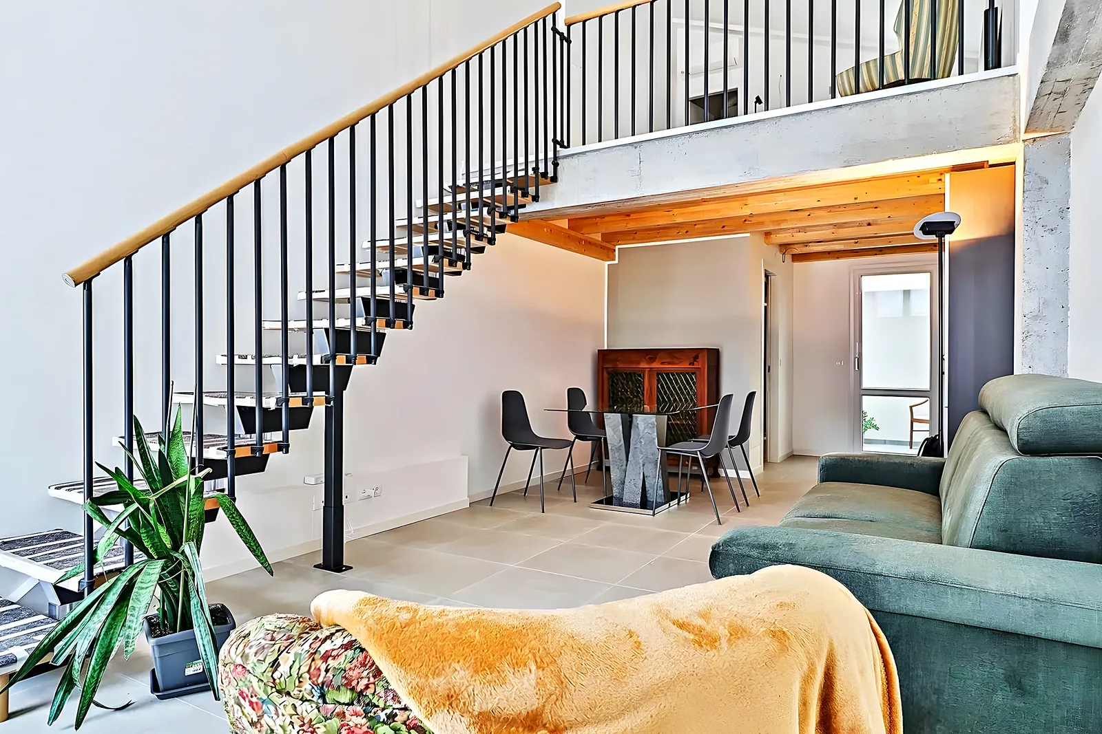 Salón con escalera de diseño en una villa reformada en la zona alta de Málaga